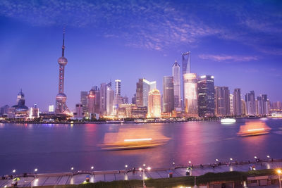 Illuminated buildings in city against sky