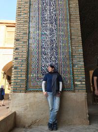 Full length of woman standing against wall