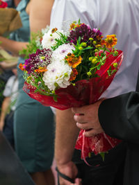 Midsection of woman holding bouquet