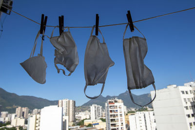 Low angle view of clothesline hanging against buildings in city