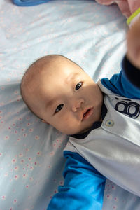 Portrait of cute boy lying on bed