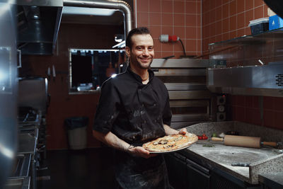 Portrait of young man standing in kitchen