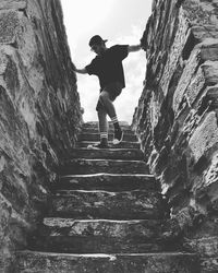 Low angle view of man moving down on steps