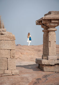 Rear view of woman standing at old ruins