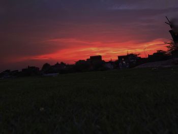 Scenic view of silhouette field against orange sky