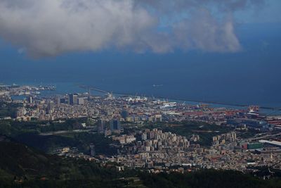 High angle view of townscape by sea against sky