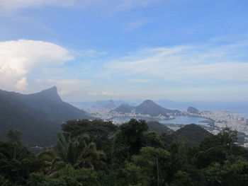 Scenic view of sea and mountains against blue sky