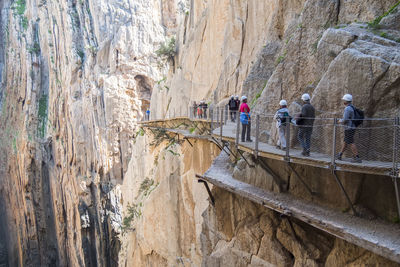 Rear view of people walking on rock