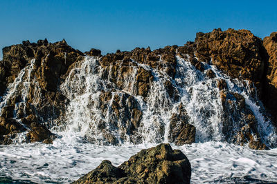 Scenic view of waterfall against clear sky