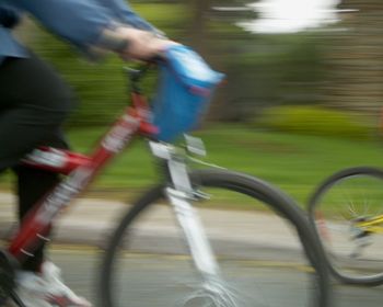 Low section of people walking on bicycle