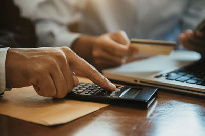 Midsection of woman using laptop on table