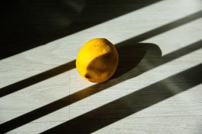 Close-up of yellow leaf on table against wall