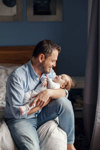 Fathers day holiday. middle age father with sleeping newborn baby. parent holding child daughter 