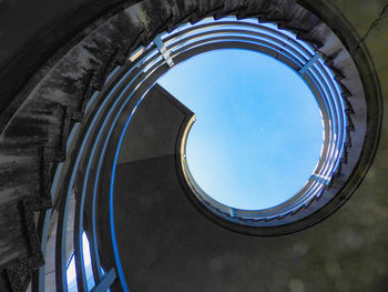 Low angle view of spiral staircase of building against blue sky
