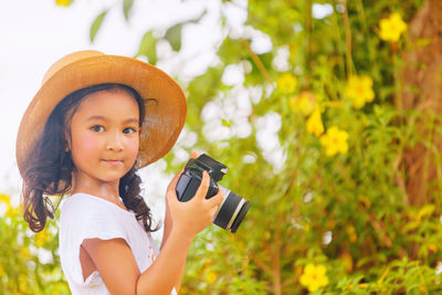 Portrait of cute smiling girl holding plants