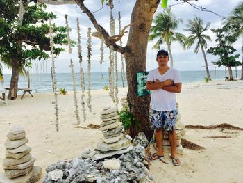 Young woman standing on tree trunk at beach