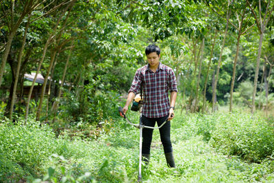 Farmer cutting grass with machinery on field