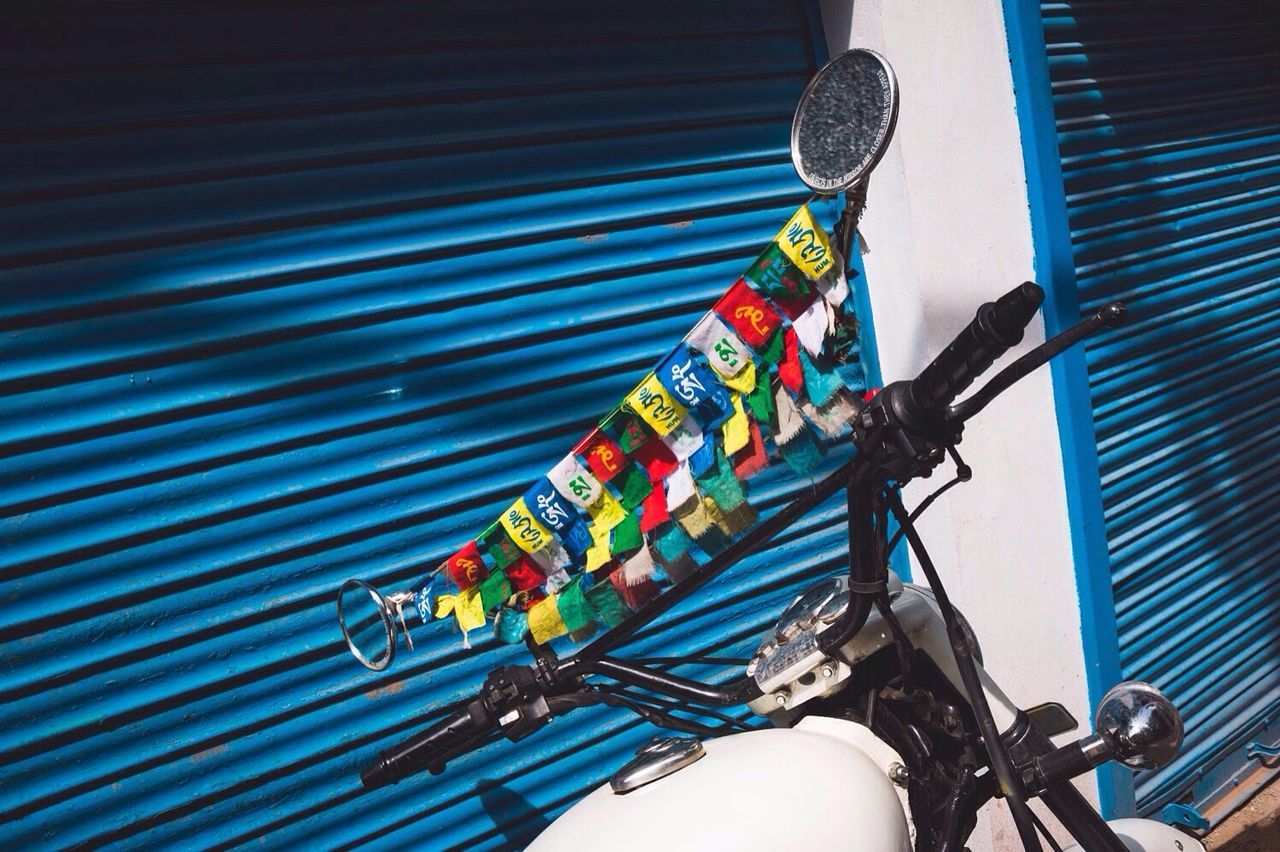 low angle view, hanging, multi colored, blue, indoors, art and craft, art, no people, decoration, creativity, variation, close-up, built structure, lighting equipment, day, architecture, wall - building feature, colorful, cable, still life