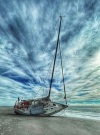 Sailboat on sea shore against sky