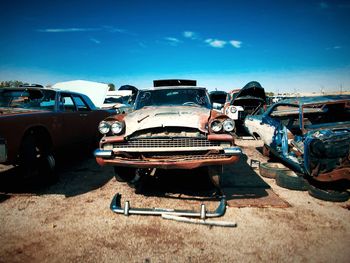 Abandoned car against blue sky