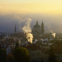 Buildings in city against sky during sunset