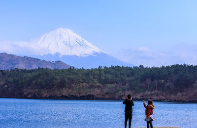 Rear view of people on mountain against sky