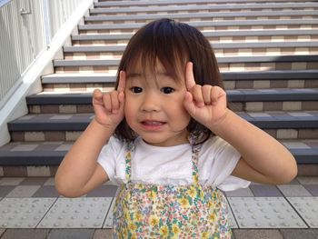 Close-up of cute girl gesturing looking away while standing on steps