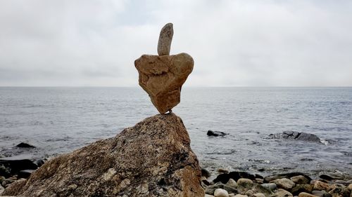 Rocks on beach against sky