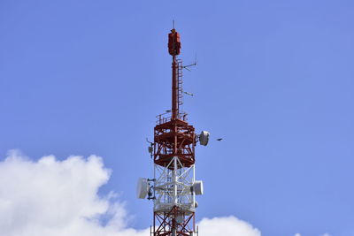 Low angle view of communications tower against blue sky