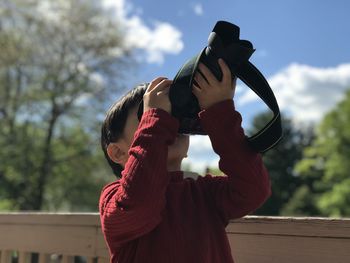 Portrait of girl photographing against sky