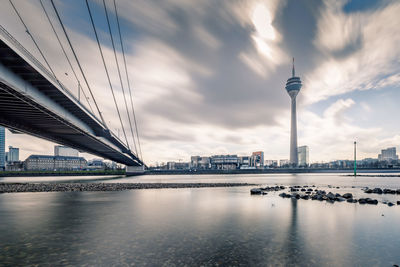 View of bridge over river against cloudy sky