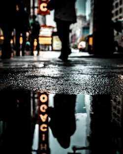 Reflection of man in puddle on road