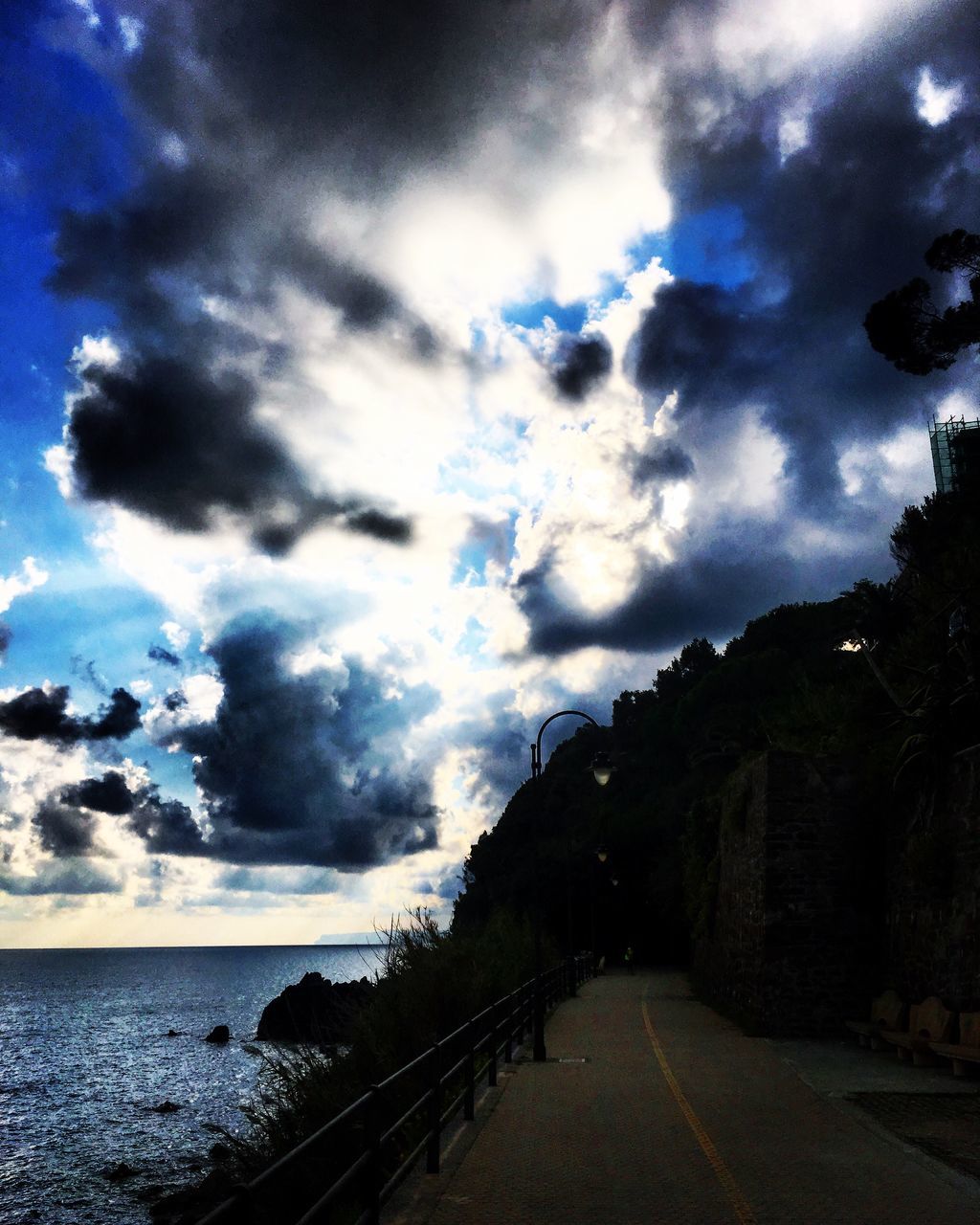 NARROW EMPTY ROAD ALONG CALM SEA