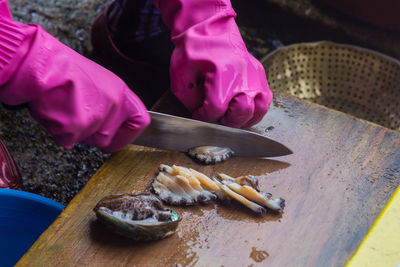 High angle view of person cutting fish on board