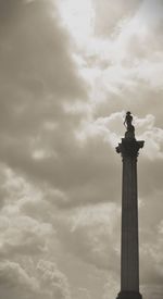 Low angle view of tower against cloudy sky