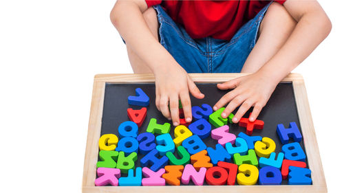 Midsection of woman holding toy blocks against white background