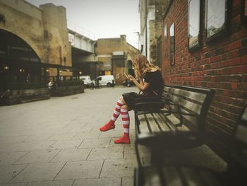 Woman relaxing in front of building