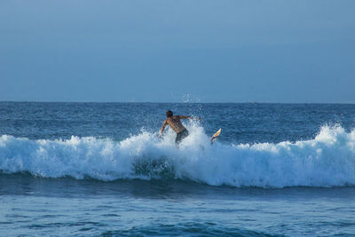People enjoying in sea against clear sky