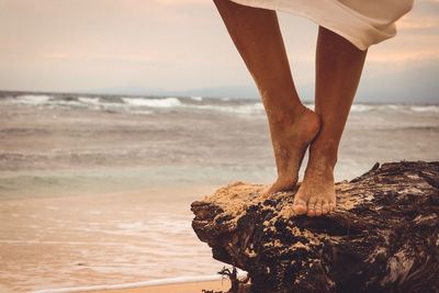 Low section of man standing on beach