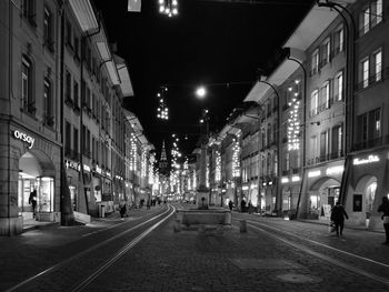 People walking on illuminated street at night