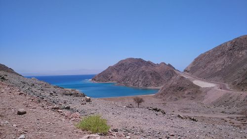 Scenic view of beach against clear blue sky