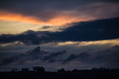 Silhouette of landscape against cloudy sky