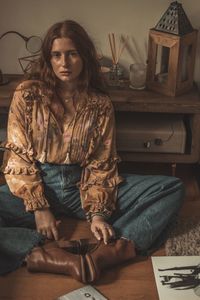 Portrait of woman sitting on floor at home