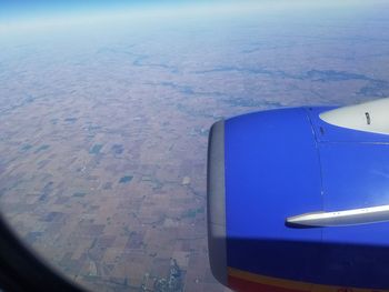 Airplane flying over landscape against sky