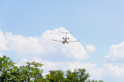 Low angle view of airplane flying against sky