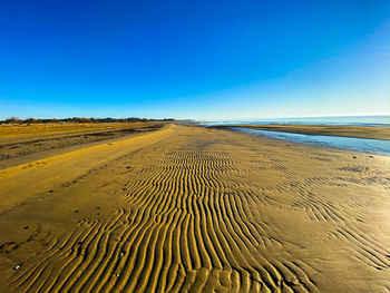Scenic view of desert against clear blue sky