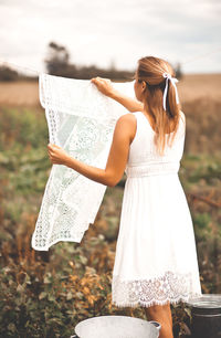 Woman hanging up laundry outdoor in a sunny day.