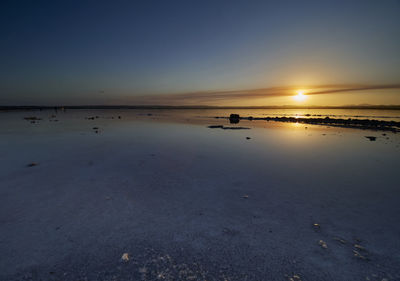 Sunset on the pink lagoon of the salt flats of torrevieja, spain