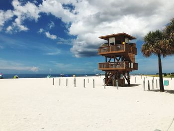 Lifeguard hut at beach against cloudy sky