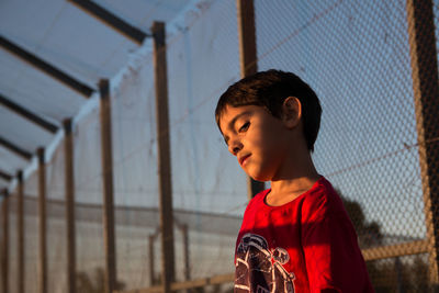 Portrait of boy against fence